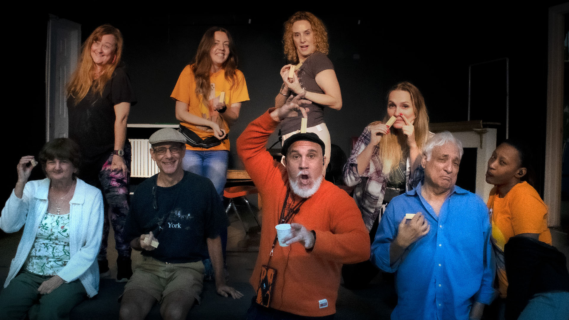 Group of actors on stage smiling.