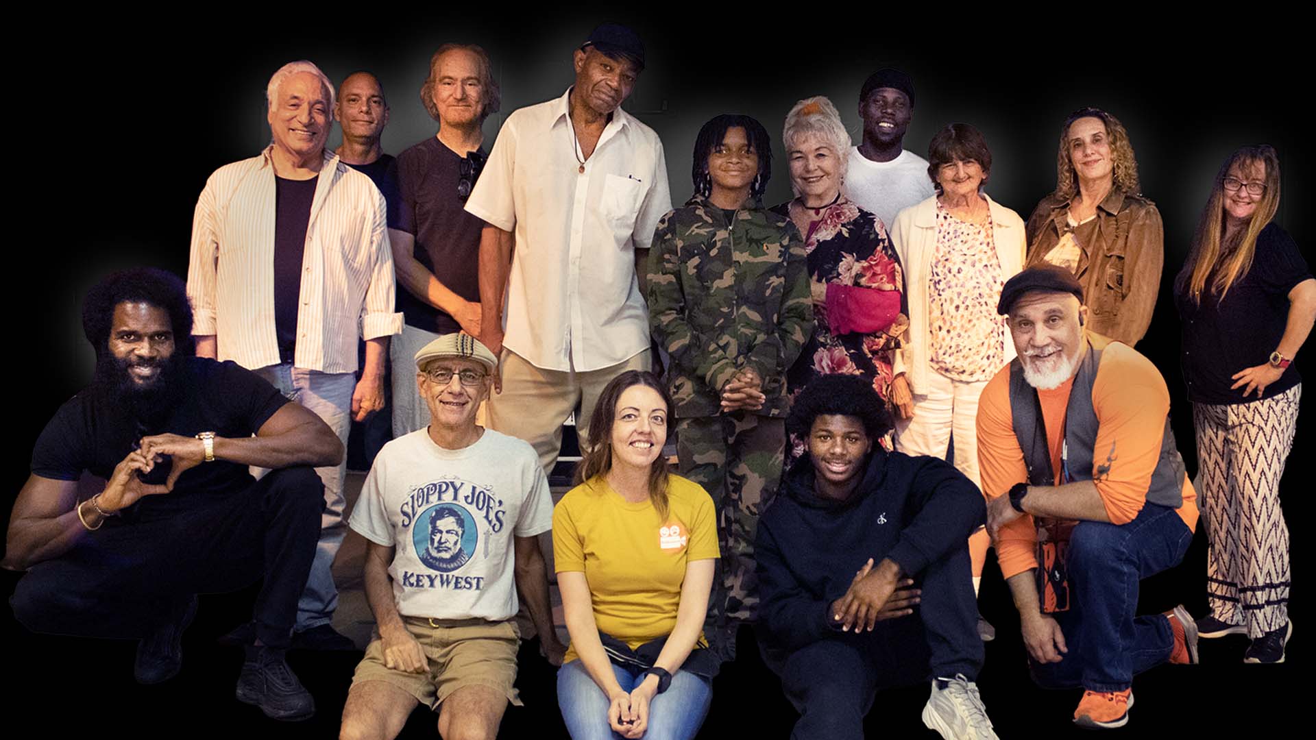 Group of actors on stage smiling.